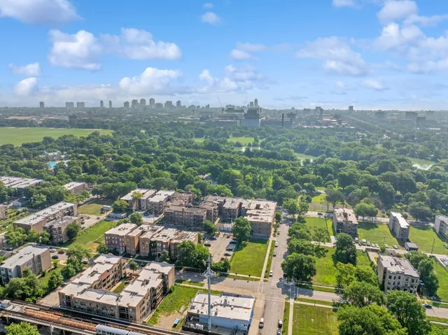 an aerial view of residential houses with outdoor space and trees