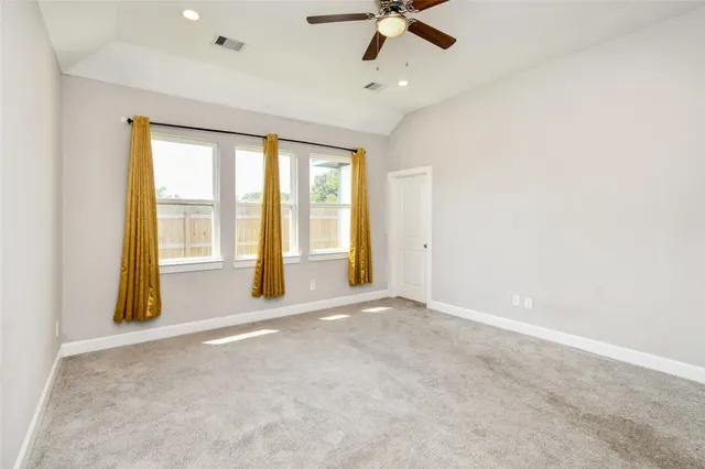 an empty room with a window and a ceiling fan