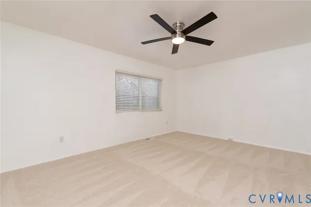 an empty room with closet and a chandelier fan