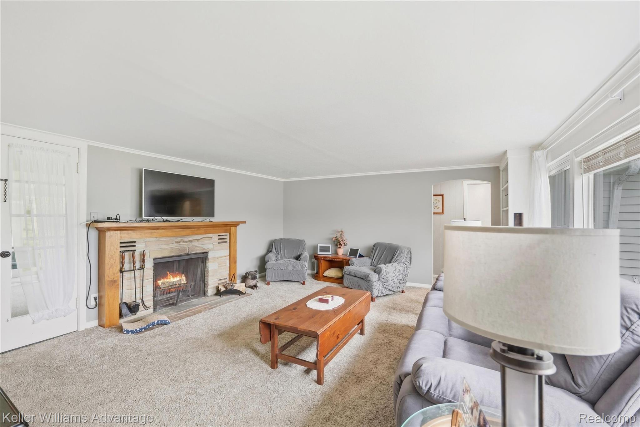 6595 Bray Road Vassar, MI 48768 - Photo 11 of 64 Carpeted living area featuring a fireplace and ornamental molding