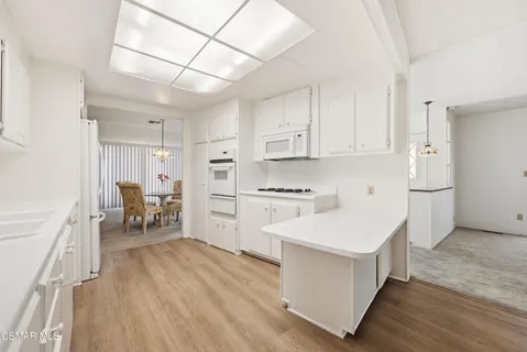 a kitchen with white cabinets and white appliances