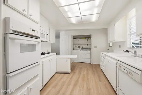 a kitchen with white cabinets and white appliances
