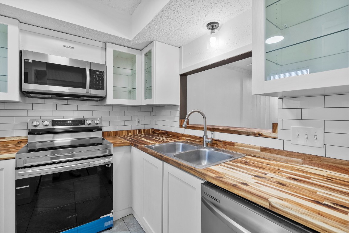 15336 West Little York Road, Unit 208 Houston, TX 77084 - Photo 19 of 33 a kitchen with stainless steel appliances a stove microwave and sink