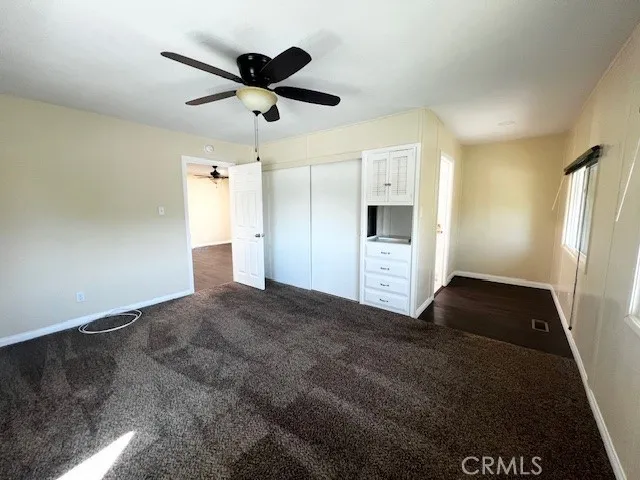 a view of empty room with wooden floor and ceiling fan