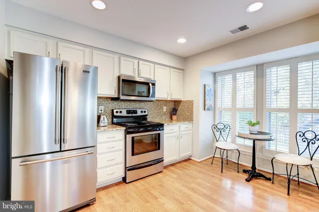 a kitchen with stainless steel appliances a refrigerator sink and microwave