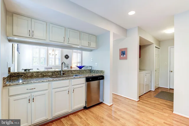 a kitchen with granite countertop a sink and cabinets