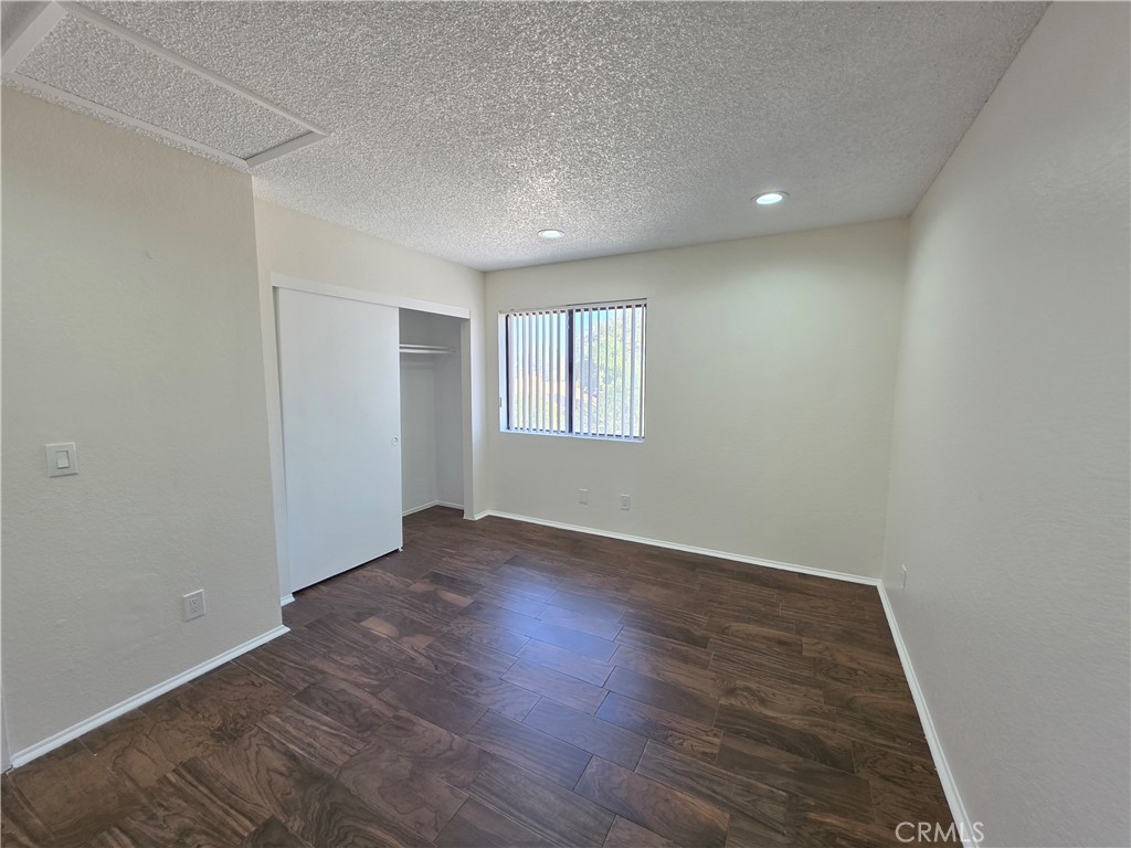 44036 25th Street West, Unit C8 Lancaster, CA 93536 - Photo 11 of 25 an empty room with wooden floor and window