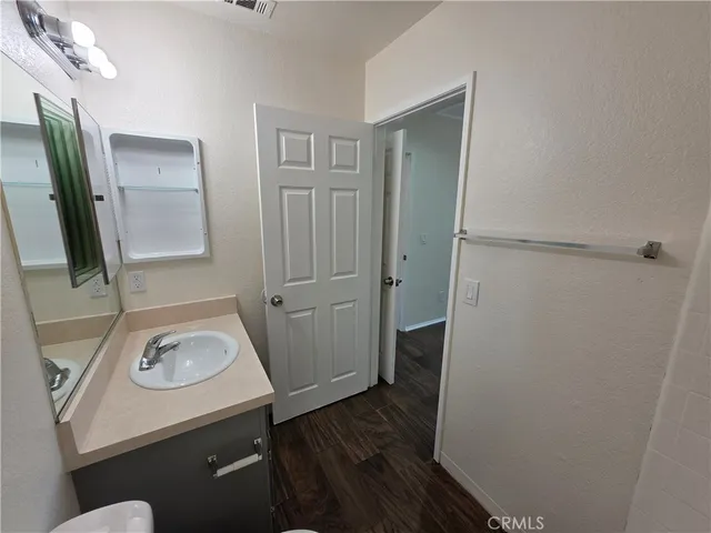 a bathroom with a sink and mirror with toilet