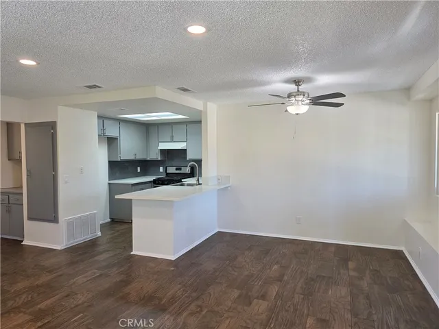 a kitchen with a refrigerator and white cabinets