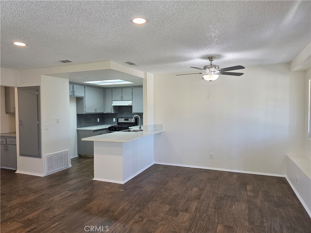 44036 25th Street West, Unit C8 Lancaster, CA 93536 - Photo 2 of 25 a kitchen with a refrigerator and white cabinets