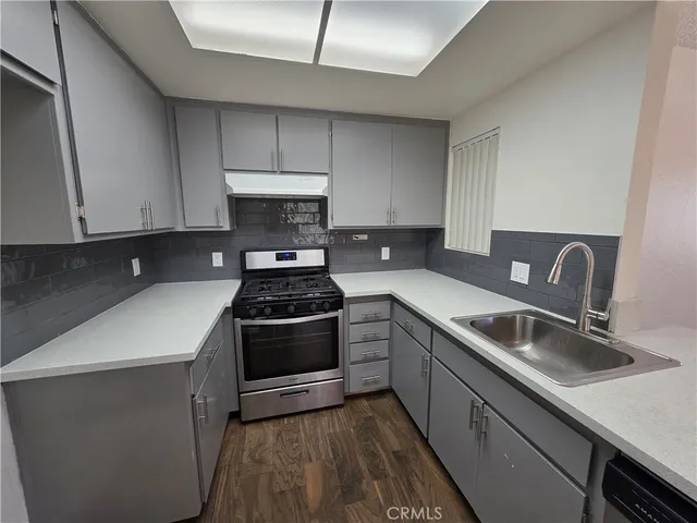 a kitchen with sink a stove and cabinets