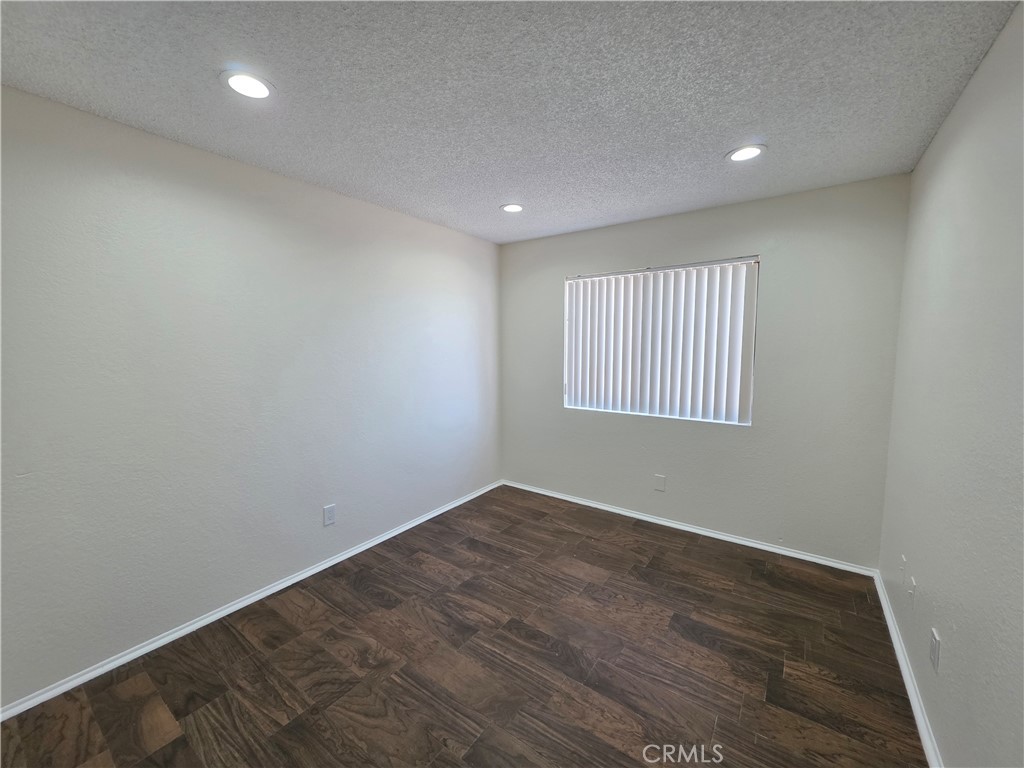44036 25th Street West, Unit C8 Lancaster, CA 93536 - Photo 9 of 25 an empty room with wooden floor and windows