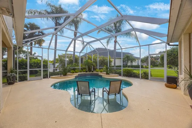 a view of a swimming pool with a yard and sitting area