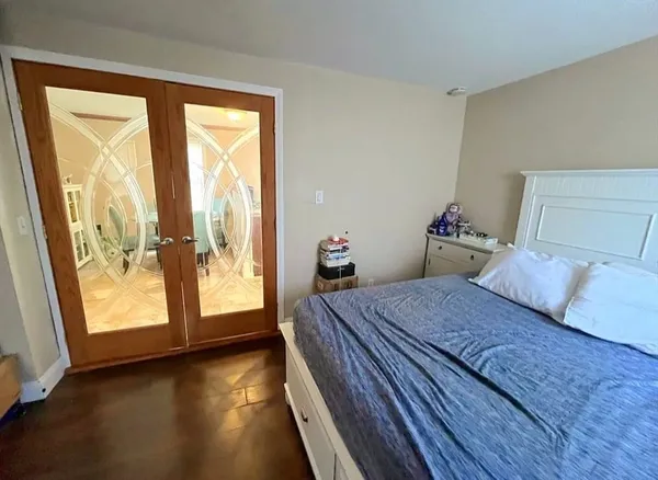 a bedroom with a bed and wooden floor