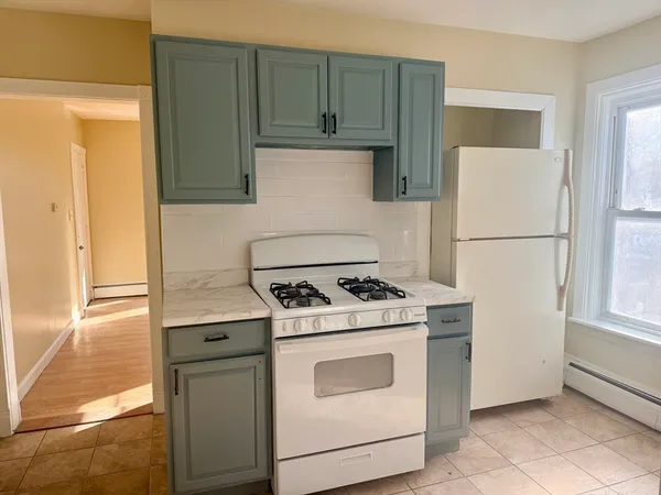 a white refrigerator freezer and a stove sitting inside of a kitchen