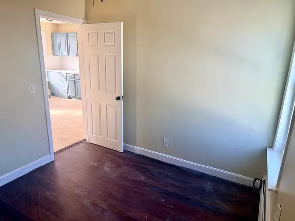 an empty room with wooden floor and a window