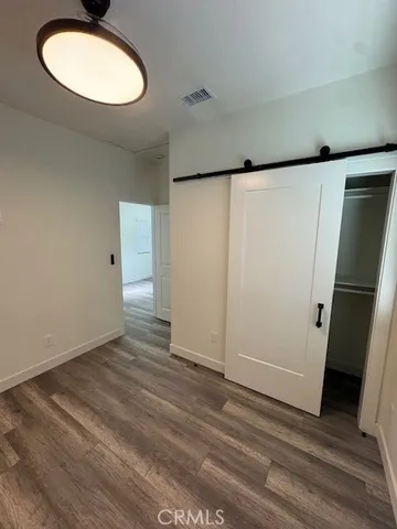 an empty room with wooden floor and mirror