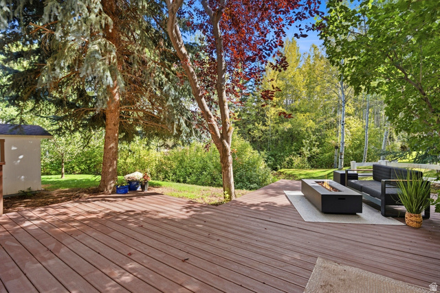 1462 Rio Grande Road Park City, UT 84098 - Photo 26 of 30 Expansive wood-finish deck with mature trees, a built-in fire feature, and a detached storage shed