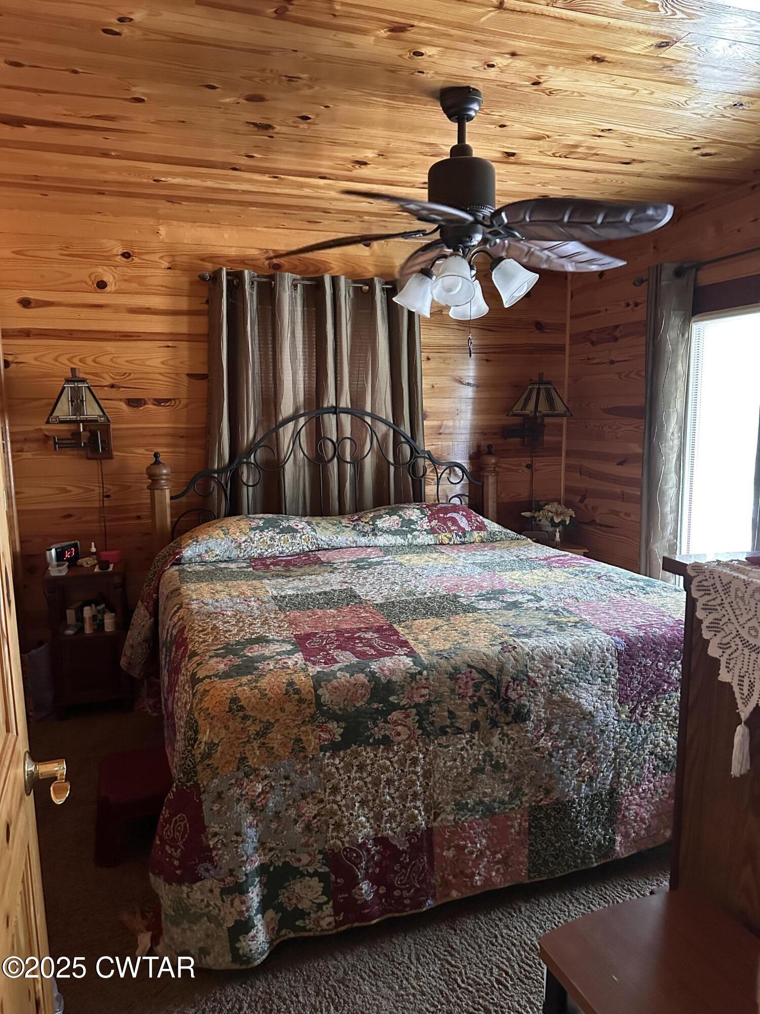 446 Miracle Road Decaturville, TN 38329 - Photo 15 of 22 a bed sitting in a bedroom next to a window