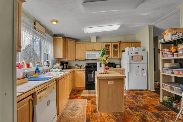 a kitchen that has a lot of cabinets and refrigerator in it