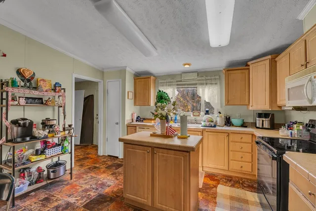 a kitchen that has a lot of cabinets a sink and appliances in it