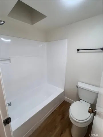 a white toilet sitting next to a bath tub