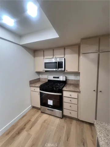 a kitchen with wooden floors and stainless steel appliances