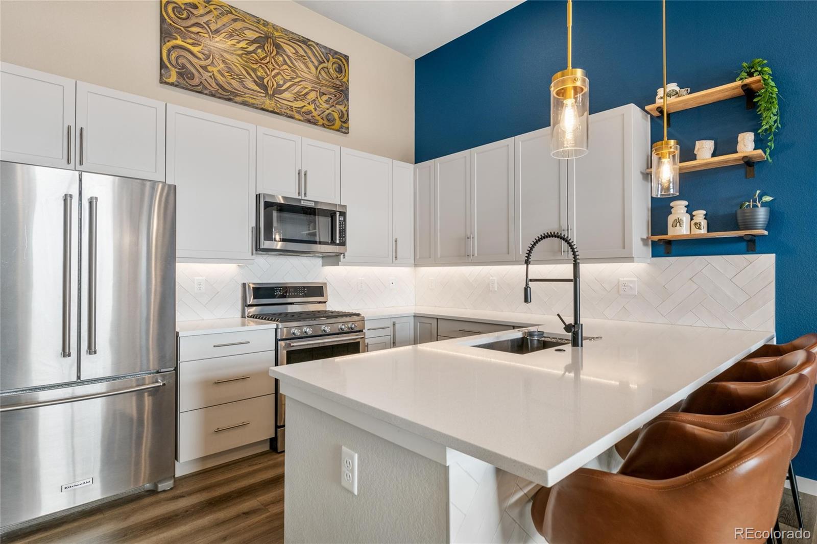 10105 Morrison Road Lakewood, CO 80227 - Photo 16 of 34 a kitchen with stainless steel appliances a refrigerator a stove a sink and white cabinets