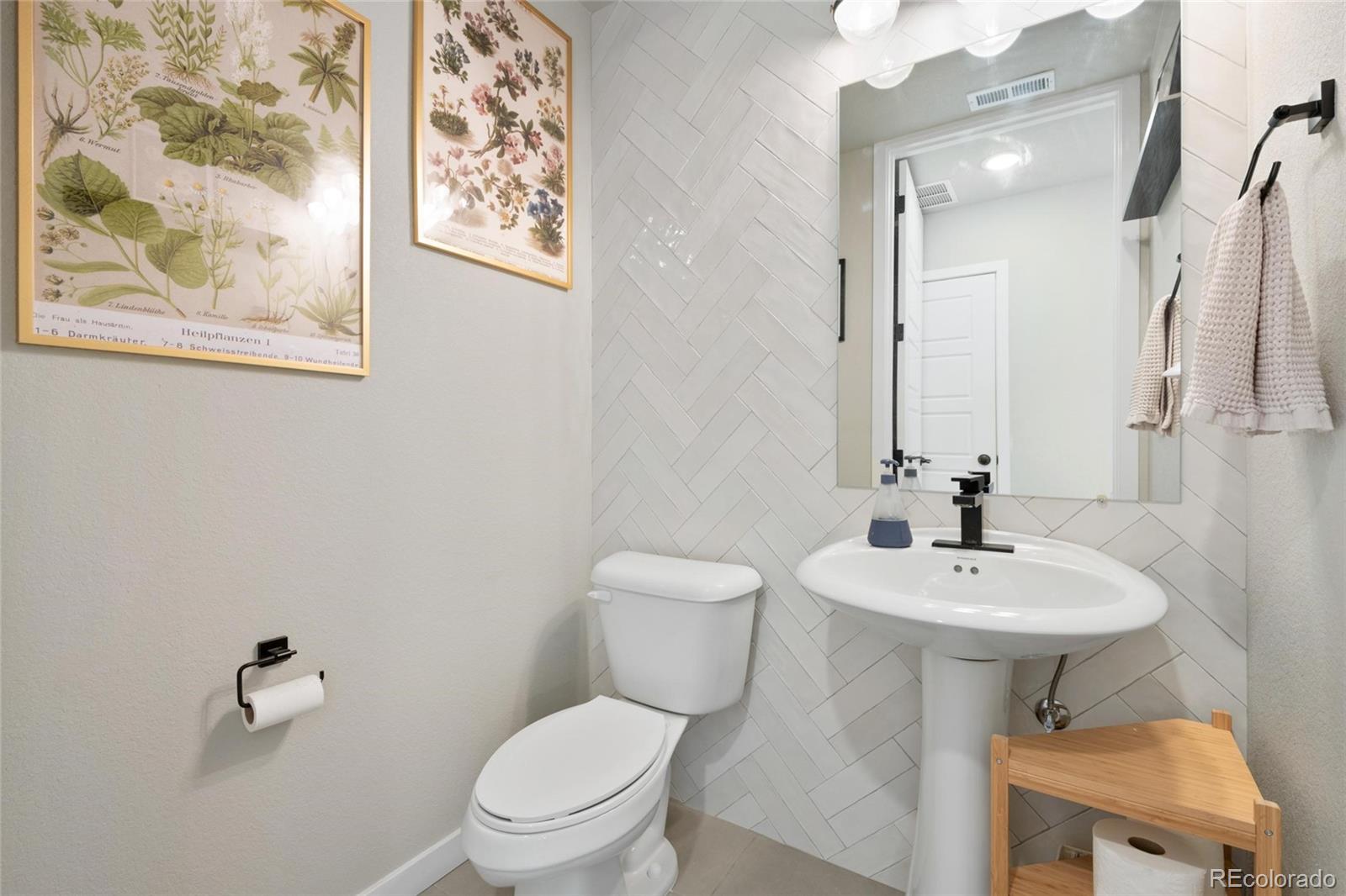 10105 Morrison Road Lakewood, CO 80227 - Photo 29 of 34 a bathroom with a toilet sink and mirror