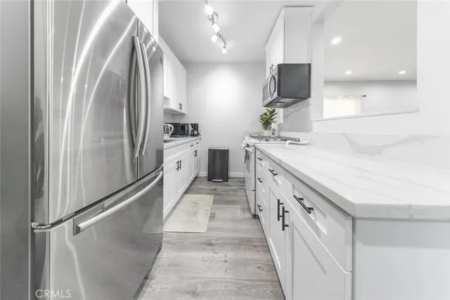 a open kitchen with stainless steel appliances granite countertop a stove a sink and a microwave