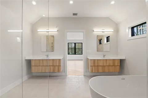 a bathroom with a tub a sink and a mirror