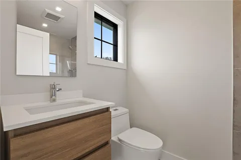 a bathroom with a sink a toilet and mirror