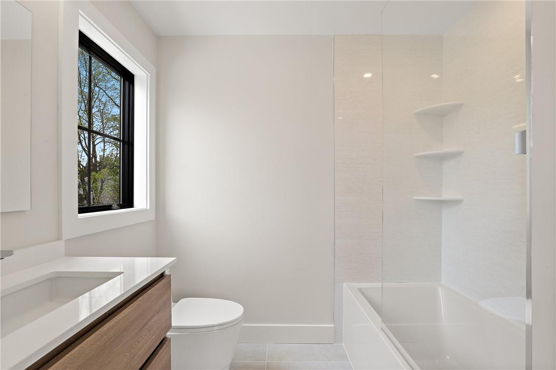 345 Betsy Brown Road Rye Brook, NY 10573 - Photo 26 of 34 a bath room with a toilet a sink and a bath tub