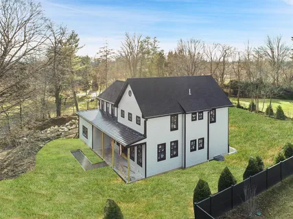 a aerial view of a house with a big yard and large trees