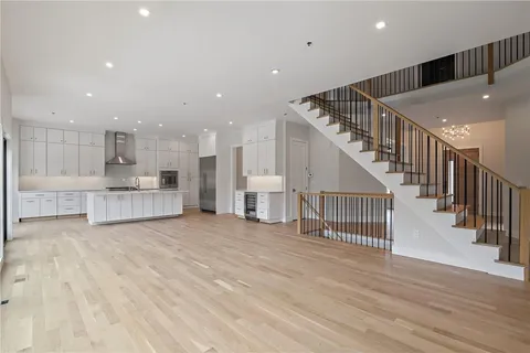 a view of a hallway with wooden floor and kitchen