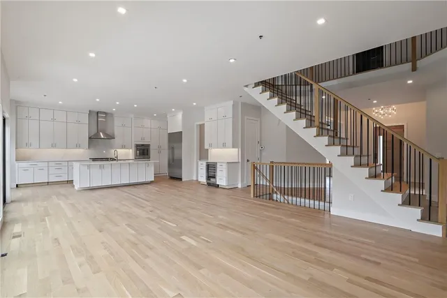 a view of a hallway with wooden floor and kitchen