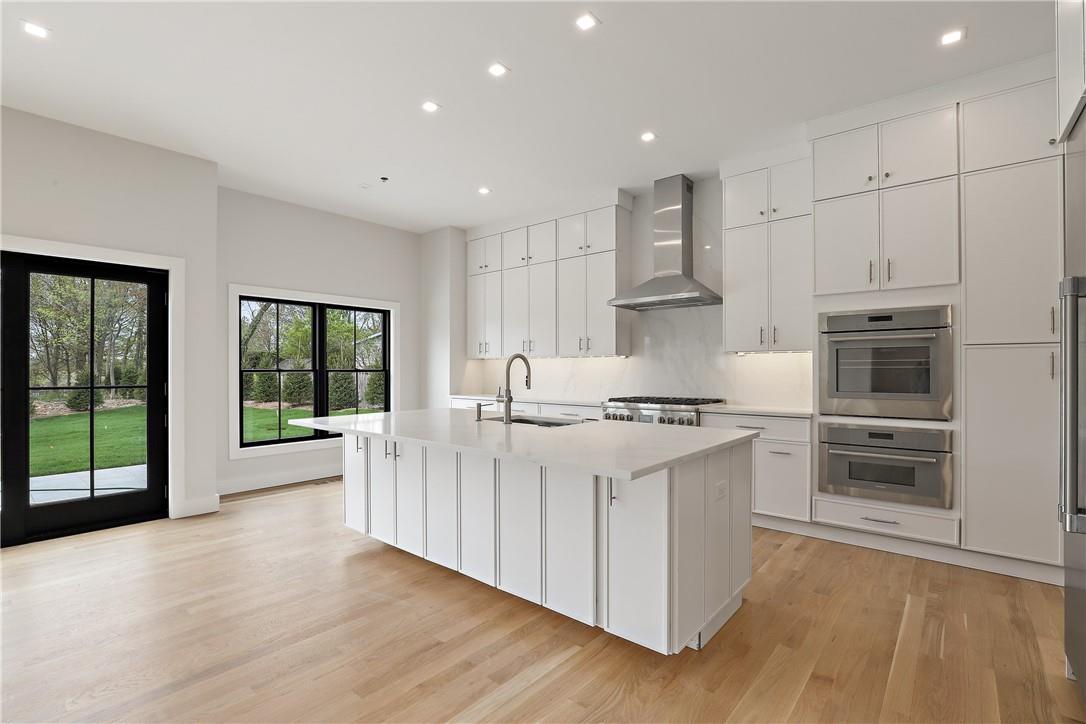 345 Betsy Brown Road Rye Brook, NY 10573 - Photo 10 of 34 a kitchen with stainless steel appliances a white stove top oven and a refrigerator with wooden floor