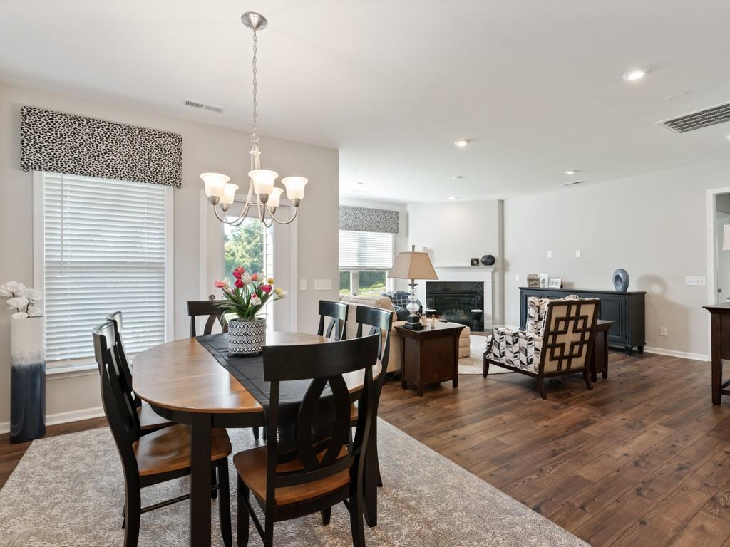 5292 Sweet Fig Way Fort Mill, SC 29715 - Photo 8 of 36 a view of a dining room and livingroom with furniture wooden floor a chandelier