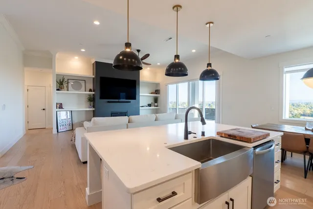 a kitchen with stainless steel appliances granite countertop a sink a stove and a wooden floor