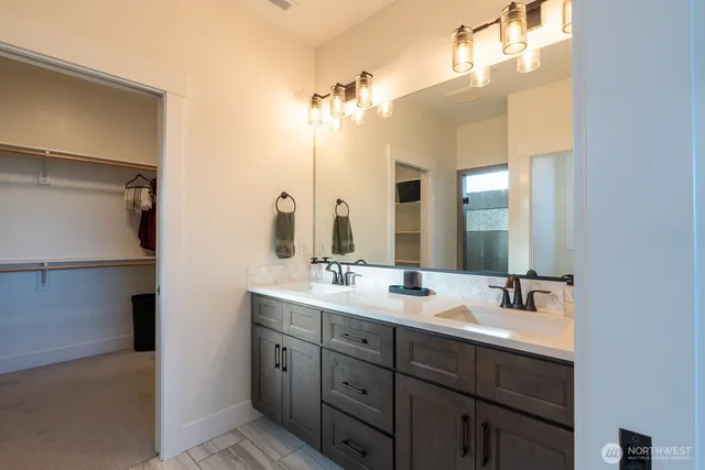 a bathroom with a double vanity sink and mirror