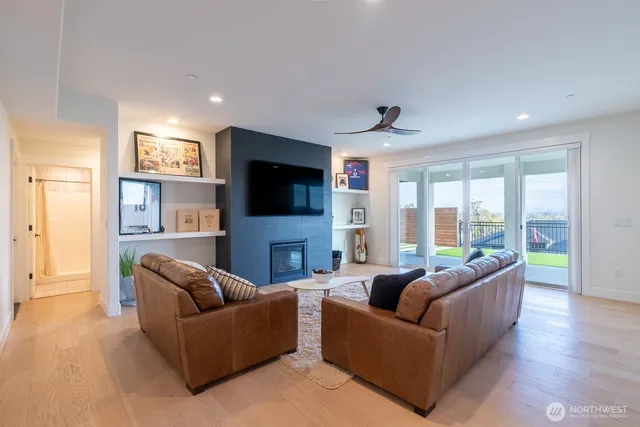 a living room with furniture a flat screen tv and a large window