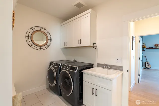 a utility room with sink dryer and washer