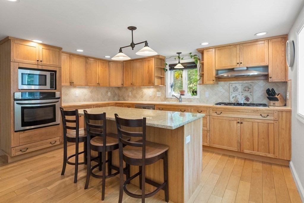 38 Elm Street Georgetown, MA 01833 - Photo 6 of 41 a kitchen with stainless steel appliances kitchen island granite countertop a table chairs sink and cabinets