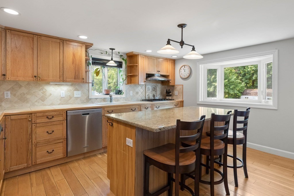 38 Elm Street Georgetown, MA 01833 - Photo 7 of 41 a kitchen with granite countertop wooden cabinets and center island
