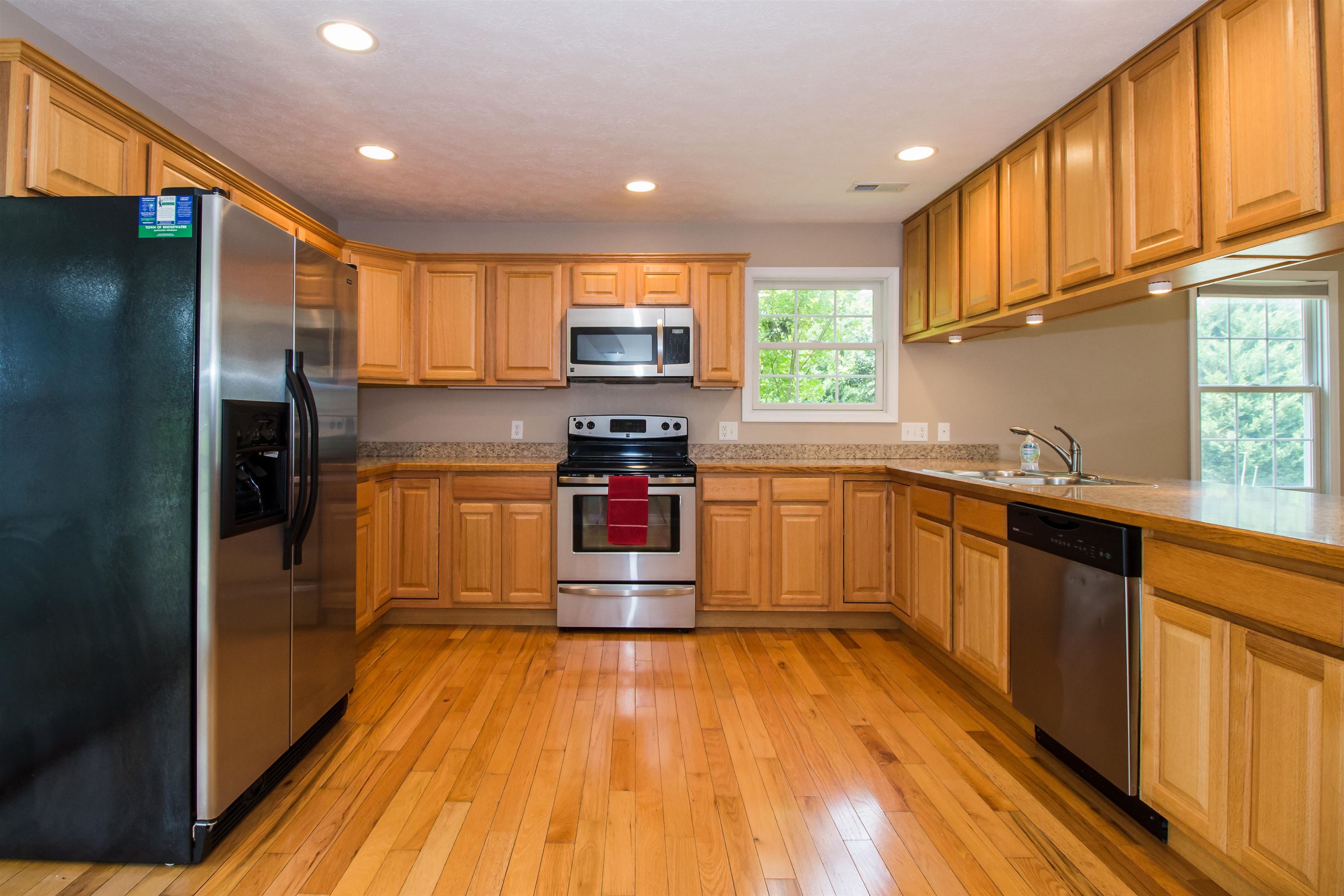 302 A North River Road Bridgewater, VA 22812 - Photo 16 of 24 a kitchen with stainless steel appliances granite countertop a refrigerator a stove top oven and a sink with wooden floors