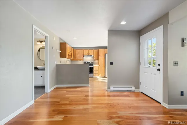 a view of a kitchen with wooden floor and a refrigerator