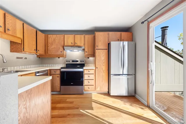 a kitchen with granite countertop a refrigerator stove top oven and sink