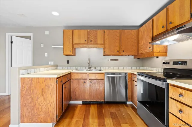 a kitchen with granite countertop wooden floors and sink