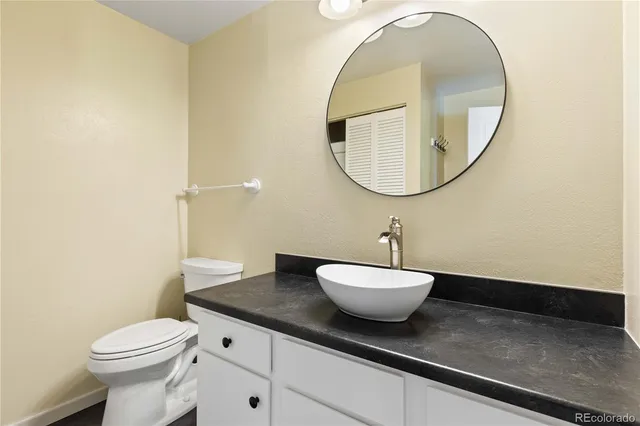 a bathroom with a toilet a sink and a mirror