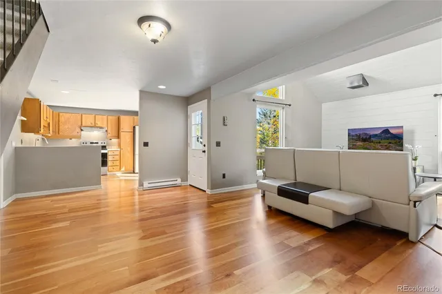 a living room with furniture and a wooden floor